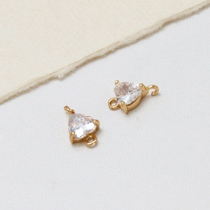 Detail of heart-shaped gold plated connector charms with clear cubic zirconia for DIY jewelry