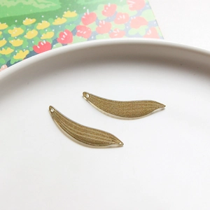 Macro detail van gebogen metalen bladhangers met geëtste textuur voor DIY sieraden maken