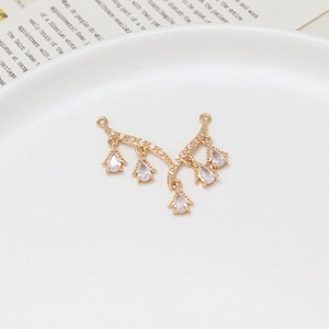Macro shot of V-shaped gold plated charm with zircon stones and pear shaped drops