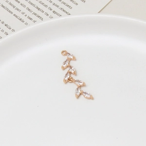 Detailed macro of gold branch pendant with marquise-cut zircons for jewelry making