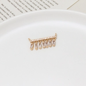 Macro detail of gold-plated willow branch pendant with micro-set zircon fringe