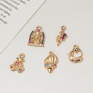 Detailed macro view of 5-piece gold-plated pendants with colorful zircon inlays for DIY
