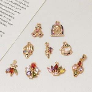 Golden copper charms with colorful cubic zirconia in frog, shell, and flower shapes