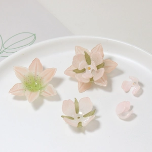 Macro detail of handmade light pink camellia resin petals for DIY hair accessories