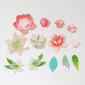 Macro view of assorted floral resin charms and leaf beads for DIY handmade hairpins