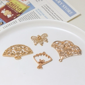 Set of four gold hollow metal jewelry parts with fans and butterfly shapes in vintage style