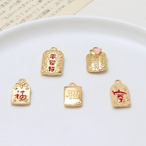 Five gold lucky charm pendants with red and pink enamel for DIY jewelry making