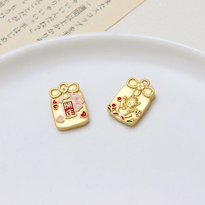 Detail of matte gold lucky bag and fortune cat charms with engraved cherry blossoms