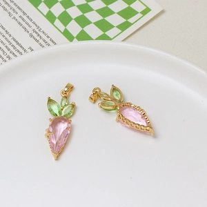 Close-up of cute pink and green crystal carrot pendants with gold metal frames for DIY