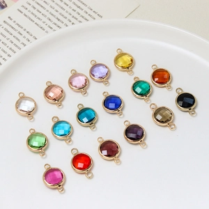 Macro detail of 10mm faceted colorful birthstone pendants with gold edge loops for DIY jewelry
