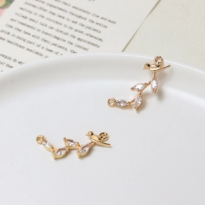 Macro shot of bird-shaped jewelry connector with marquise cubic zirconia on a gold branch