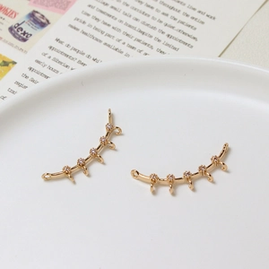 Macro detail of gold-plated crescent connector with zircon stones and five hanging loops