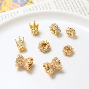 Macro shot of gold-plated crown and bow charms with cubic zirconia for DIY jewelry making