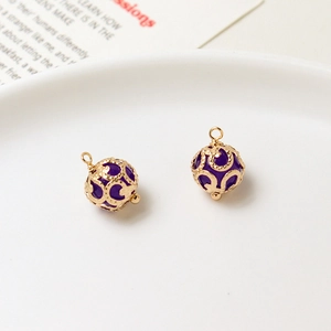 Macro detail of copper hollow ball pendants with purple crystal beads for DIY jewelry