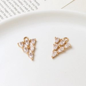 Detailopname van twee gouden zirkonia-hangers in druppelvorm voor doe-het-zelf sieraden maken