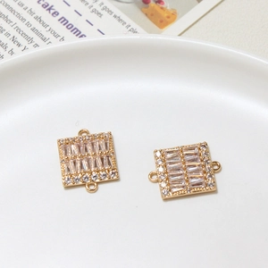 Détail de connecteurs carrés dorés sertis de zircons cubiques baguettes et ronds