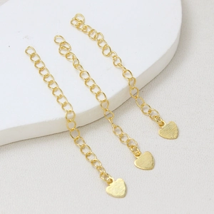Détail de trois chaînes d'extension plaquées or 18 carats avec pendentifs en forme de cœur