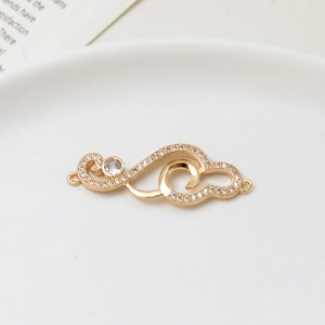 Macro shot of gold-plated wave pendant with micro-set zircons and dual-loop connectors