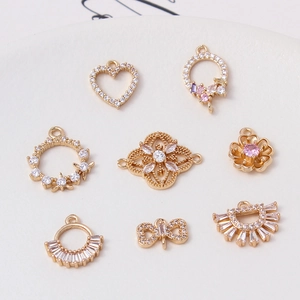 Detailed view of gold-plated copper flower and heart pendants with cubic zirconia