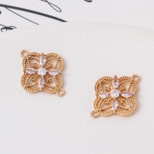 Macro view of gold flower charms with sparkling zircon inlay for DIY jewelry design