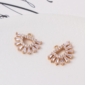 Macro shot of gold-plated fan-shaped charms with micro-pave cubic zirconia stones