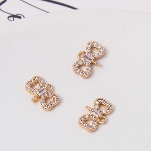 Close-up of golden bow jewelry charms with cubic zirconia for DIY bracelets