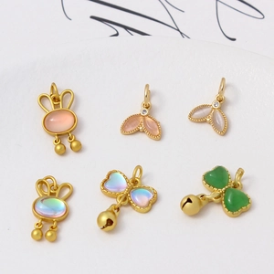 Detailed macro view of six gold-plated bunny and butterfly charms for DIY jewelry making