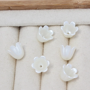 Detalle de seis cuentas de flores de lirio de los valles acrílicas para joyería artesanal