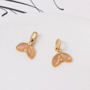 Macro shot of gold-plated leaf pendants with pink cat-eye stones and zircon for DIY jewelry