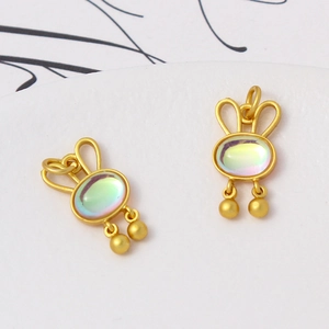 Detail of rabbit jewelry pendants with matte gold finish and iridescent opal inlays