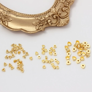 Perles d'espacement triangulaires dorées pour bijoux DIY sur fond blanc