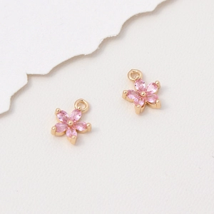 Nahaufnahme der rosa Blütenanhänger mit goldener Basis und Zirkon-Blütenblättern für DIY