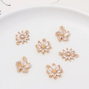 Detailed macro shot of 6 gold plated daisy flower charms with cubic zirconia stones