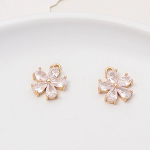 Macro detail of two gold-plated flower pendants with sparkling zircon crystal petals