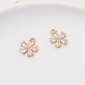 Macro detail of gold-plated five-petal flower pendants with drop-shaped zircon inlays
