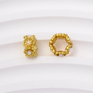 Vista macro de cuentas de flores doradas mate con centros de perlas blancas para joyería DIY