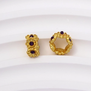 Detalle de cuenta espaciadora de flor dorada con gema púrpura para joyería artesanal
