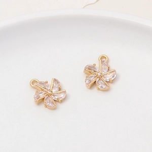 Detail of two gold flower pendants with marquise zirconia petals for DIY jewelry making