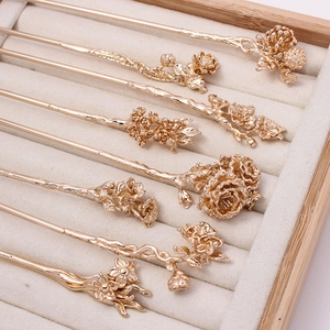 Detailed close-up of seven golden floral hairpins with intricate traditional carvings