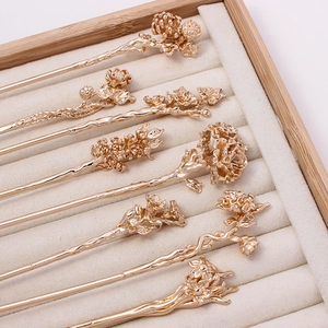 Golden flower hairpins set in traditional Chinese style on jewelry tray