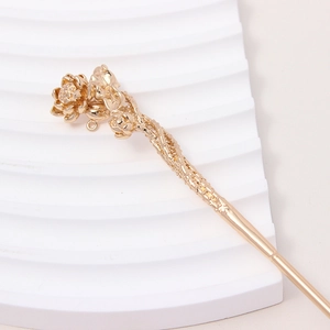 Macro detail of a golden lotus flower hair pin with intricate metal floral textures