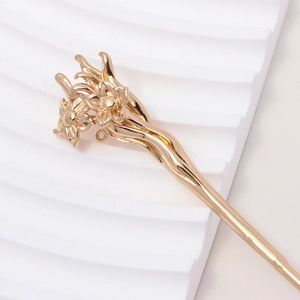 Macro view of gold flower hair pin featuring intricate petal textures and vintage style