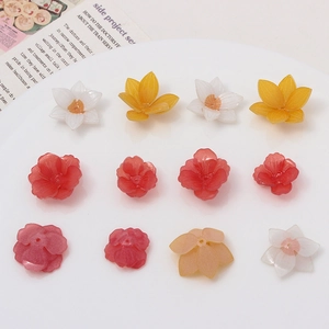 DIY resin frangipani charms in yellow and white displayed for handmade jewelry