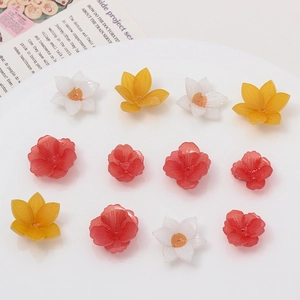 Flat lay of colorful resin plumeria flower charms with holes for DIY jewelry making