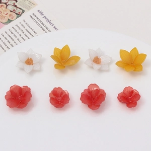 Detail of colorful resin plumeria flower beads with central holes for DIY jewelry making