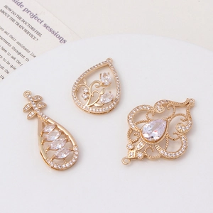 Macro view of gold-plated teardrop and vintage hollow pendants with inlaid zircon stones
