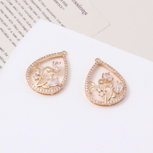 Detail of gold teardrop pendants with micro-set zircon and vintage floral hollow design