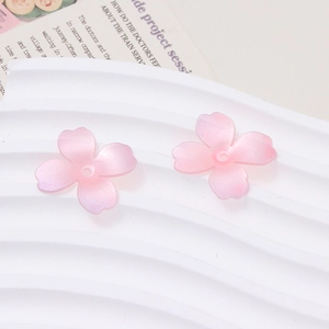 Detailed view of pink cherry blossom heat-shrink resin flower charms with center holes
