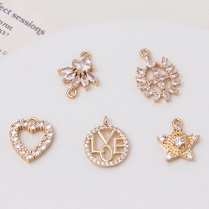 Detailed view of five gold-plated zircon pendants including heart and star shapes