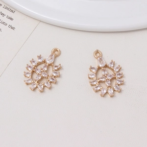 Detailed view of two gold crystal snowflake pendants for DIY jewelry making and crafts